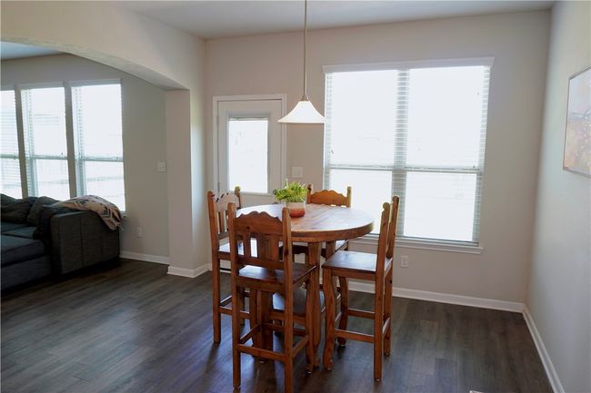 Dining area with dark wood finished floors, baseboards, and arched walkways | Image 8