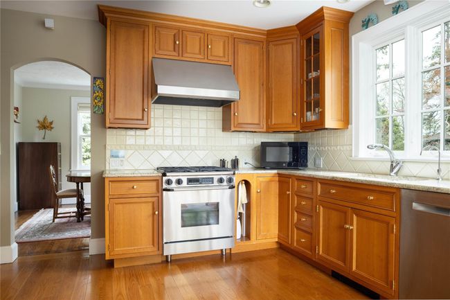 Kitchen with stainless steel appliances, cherry cabinets , arched entry into Dining Room and opening into breakfast room. | Image 12