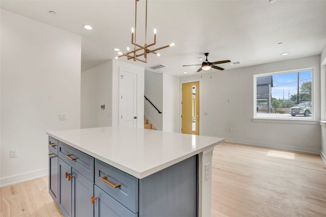 Kitchen with a ceiling fan, light wood-type flooring, a center island, recessed lighting, and gray cabinetry | Image 21