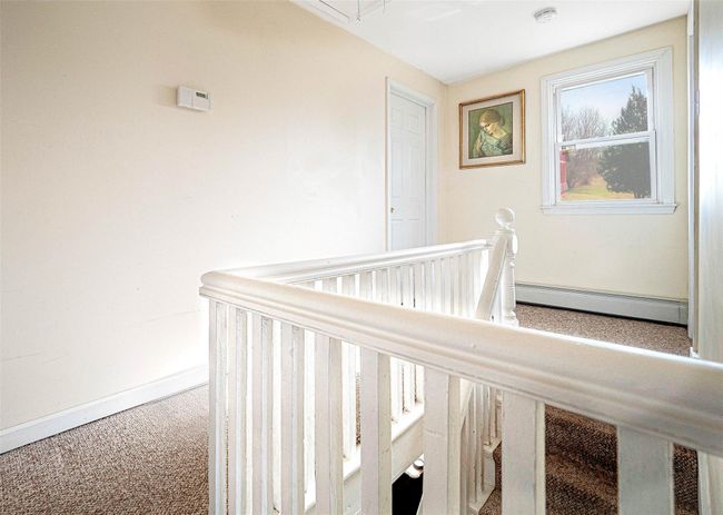 Hallway featuring baseboard heating and carpet | Image 11