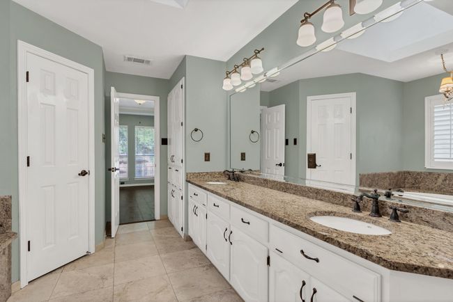 Full bathroom with double vanity, a skylight, a garden tub, and tile patterned floors | Image 19