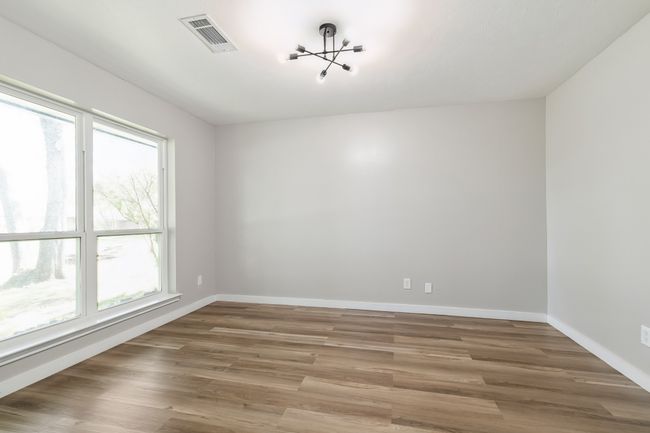Spare room with an inviting chandelier, visible vents, wood finished floors, and baseboards | Image 19