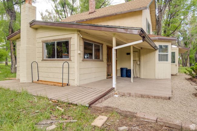 Back of house featuring a chimney, a shingled roof, and a wooden deck | Image 6