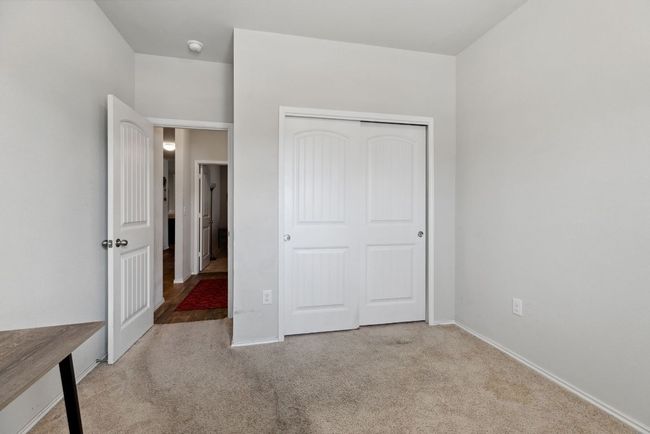Unfurnished bedroom featuring carpet floors, a closet, and baseboards | Image 11