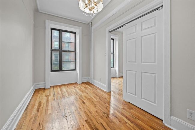 Foyer featuring healthy amount of natural light, light wood-type flooring, and a chandelier | Image 4