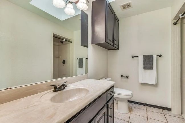 Bathroom with visible vents, toilet, tile patterned floors, walk in shower, and vanity | Image 18