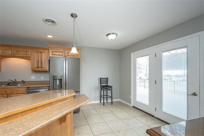 Kitchen with visible vents, a sink, decorative light fixtures, light tile patterned floors, and dishwasher | Image 12