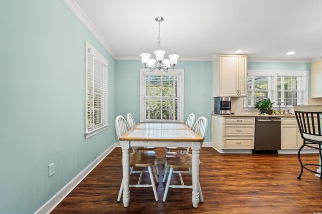 Dining room with a chandelier, dark wood-style flooring, crown molding, and recessed lighting | Image 4