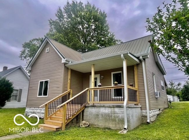 rear view of house featuring a lawn, covered porch, a metal roof, and cooling unit | Image 10