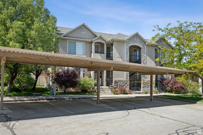 View of front facade with stucco siding, stone siding, and covered parking | Image 24