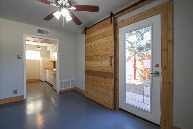 Entryway with a barn door, a ceiling fan, and concrete flooring | Image 6