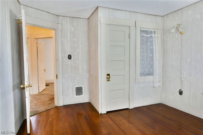 Unfurnished bedroom featuring a closet, a textured ceiling, and dark wood-type flooring | Image 25