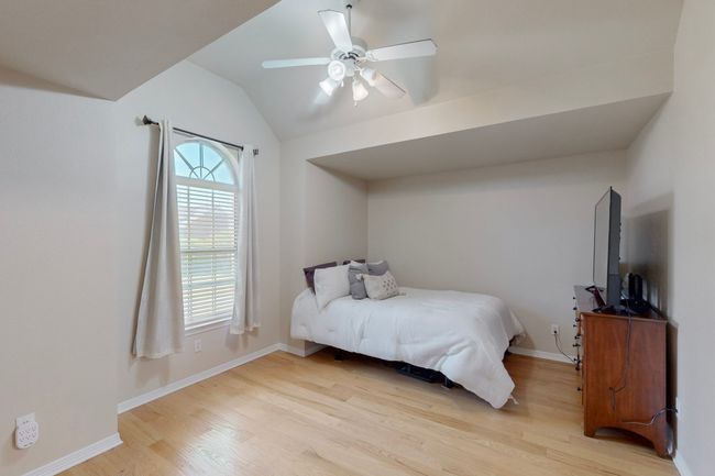 Bedroom featuring lofted ceiling, a ceiling fan, baseboards, and light wood-style floors | Image 24