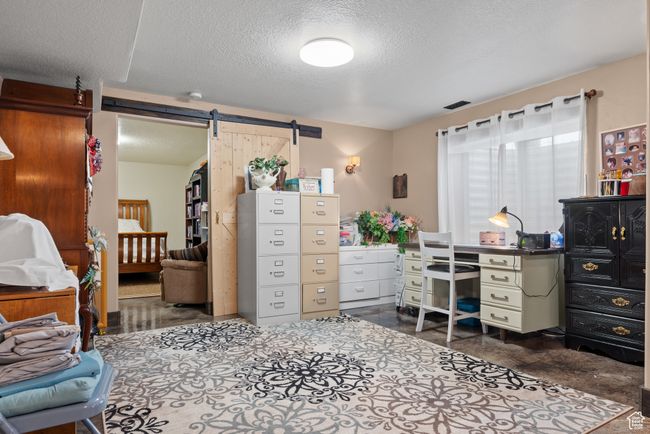 Office space with visible vents, a barn door, and a textured ceiling | Image 24