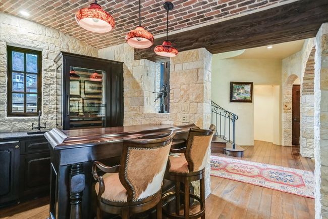 Bar with brick ceiling, wood-type flooring, wet bar, a sink, and arched walkways | Image 17
