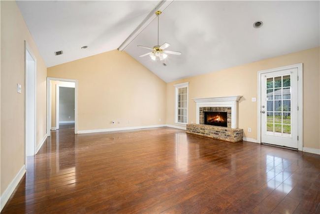 Unfurnished living room featuring a ceiling fan, hardwood / wood-style floors, and a brick fireplace | Image 6
