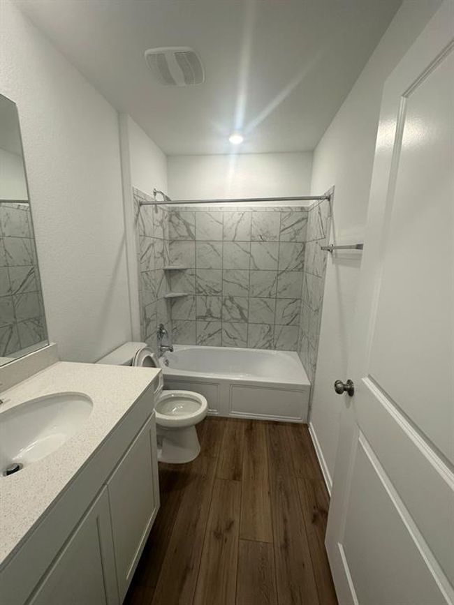 Bathroom featuring wood finished floors, shower / bathtub combination, toilet, and vanity | Image 11