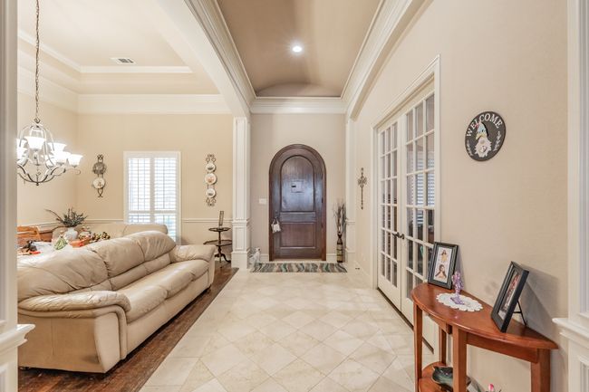 Foyer entrance featuring a chandelier, ornamental molding, and a raised ceiling | Image 9