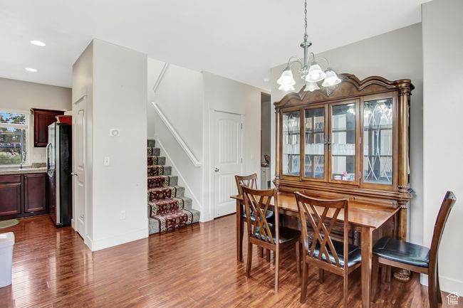 Dining space featuring a chandelier, dark wood-type flooring, stairs, and recessed lighting | Image 11