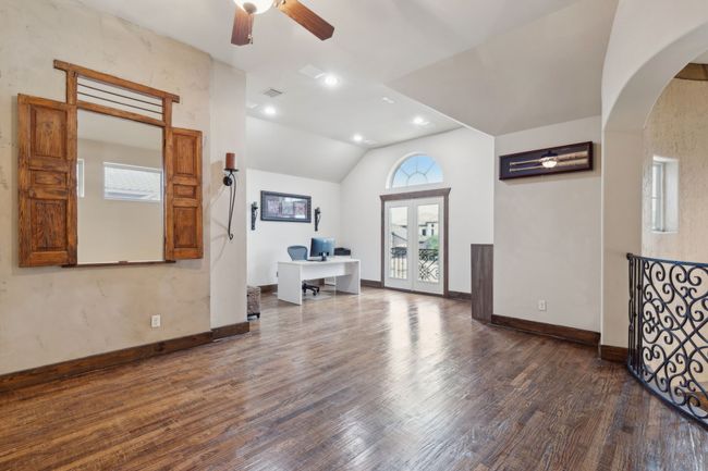 Living room with wood finished floors, ceiling fan, arched walkways, baseboards, and lofted ceiling | Image 23
