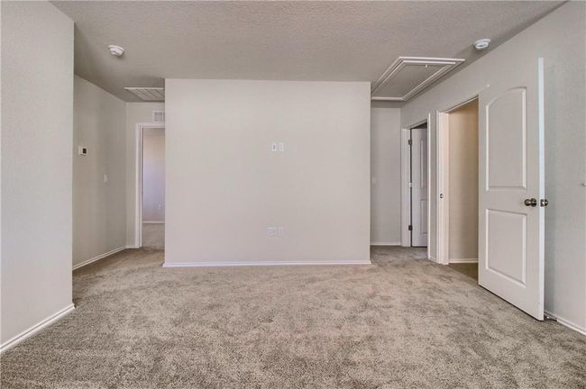Carpeted empty room featuring attic access, a smoke detector, baseboards, and a textured ceiling | Image 19