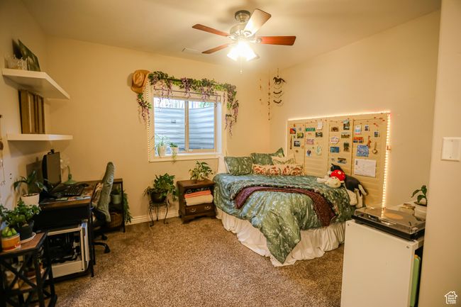 Bedroom with carpet flooring, a desk, ceiling fan, and baseboards | Image 50