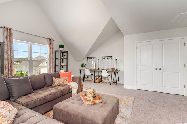 Carpeted living room with vaulted ceiling and baseboards | Image 23