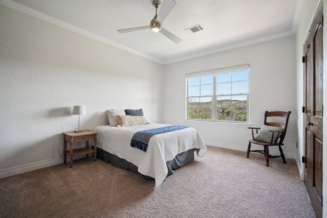 Carpeted bedroom featuring ceiling fan, baseboards, visible vents, and ornamental molding | Image 24