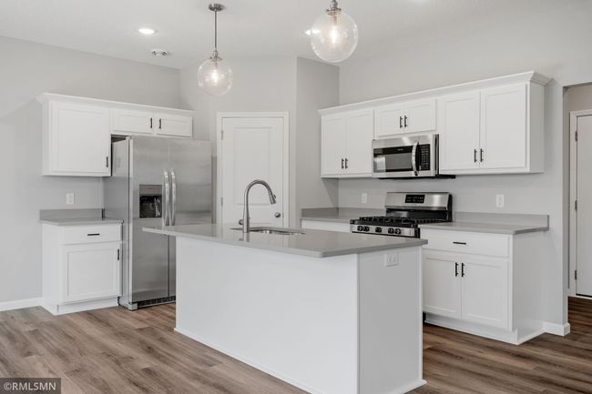 (Photo of previously finished home) Stylish, durable countertops paired with modern appliances and sleek white cabinetry. | Image 4
