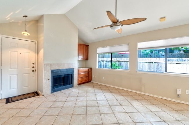 The spacious and bright living room features vaulted ceilings, gas fireplace, wet bar, ceiling fan and is filled with abundant natural light. | Image 6