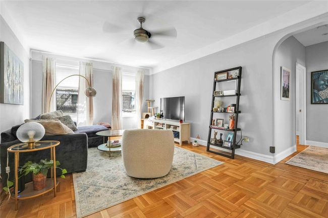 Living area featuring ceiling fan, arched walkways, and baseboards | Image 13