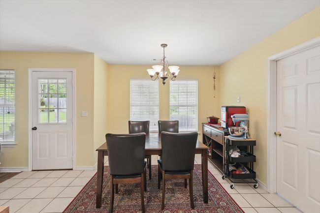 Dining area with a chandelier, a wealth of natural light, and light tile patterned flooring | Image 14