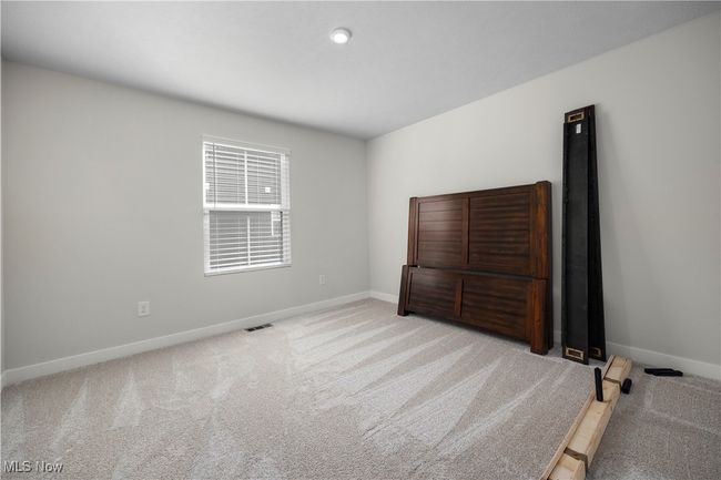Carpeted bedroom featuring visible vents and baseboards | Image 11