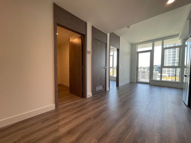Empty room with dark wood-type flooring, visible vents, and baseboards | Image 10