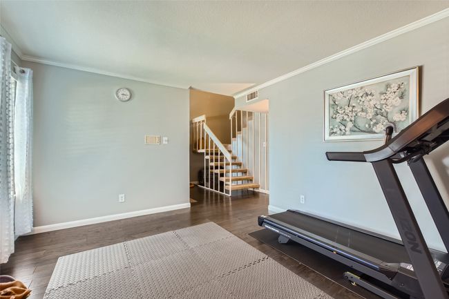 Exercise room with ornamental molding, wood finished floors, and baseboards | Image 11