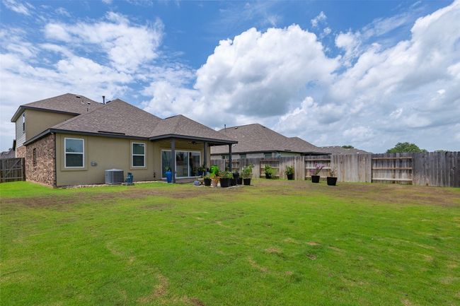 Rear view of property featuring a fenced backyard, a shingled roof, brick siding, and stucco siding | Image 32