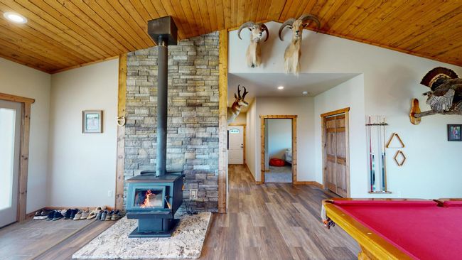 Game room with recessed lighting, wood finished floors, wood ceiling, a wood stove, and lofted ceiling | Image 13