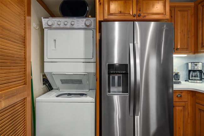 Stacked washing machine and dryer located in closet next to kitchen | Image 14