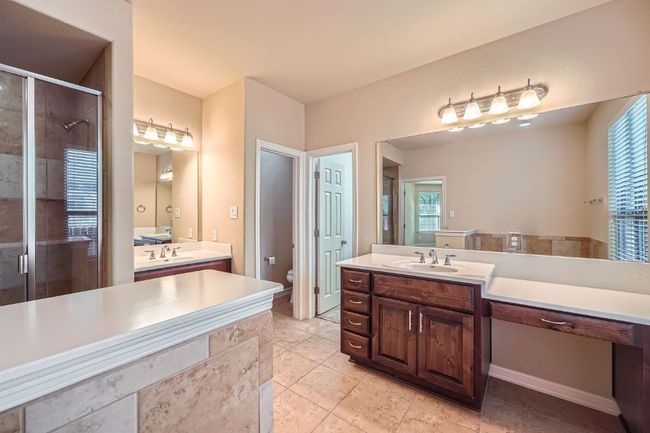 Bathroom featuring a shower stall, two vanities, and healthy amount of natural light | Image 19