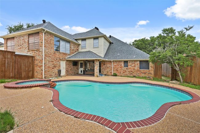 View of pool with a patio area, a fenced backyard, and a pool with connected hot tub | Image 32