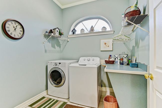 Laundry area with laundry area, ornamental molding, light tile patterned floors, washing machine and clothes dryer, and baseboards | Image 27