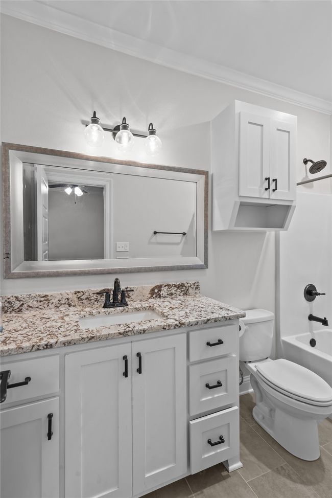 Full bath featuring ornamental molding, vanity, tile patterned floors, and tub / shower combination | Image 22
