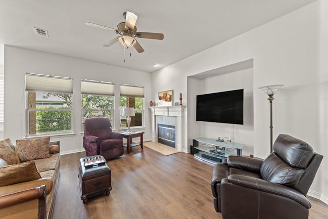 Living area featuring wood finished floors, a fireplace, ceiling fan, and baseboards | Image 12