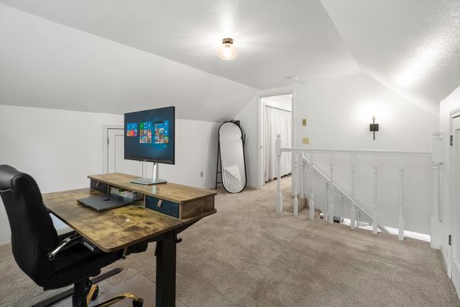 Office space featuring vaulted ceiling and light colored carpet | Image 28