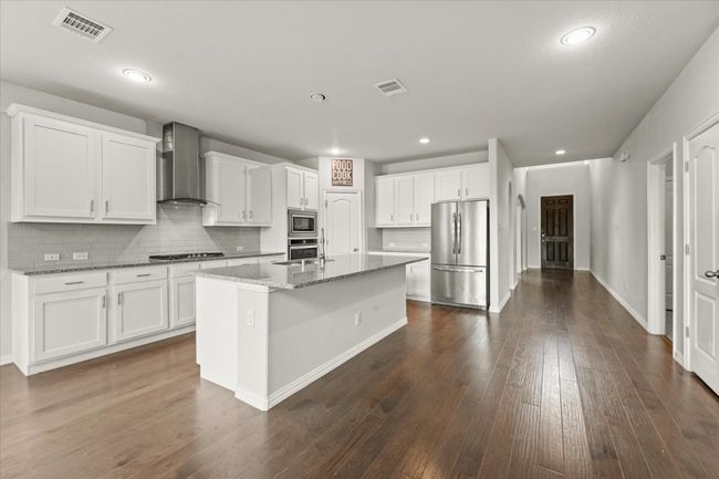 Kitchen featuring a center island with sink and stainless steel appliances | Image 7