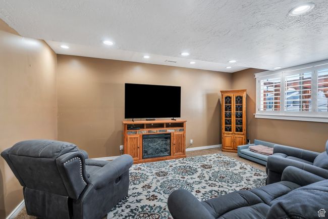 Living room featuring carpet flooring, a textured ceiling, and recessed lighting | Image 16