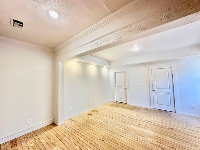 Unfurnished room featuring crown molding, light wood-style flooring, a textured ceiling, and recessed lighting | Image 10