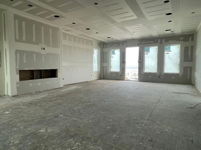 The second-floor game room or secondary living area takes shape — complete with fireplace framing and Gulf-facing windows that elevate both value and ambiance. These sightlines are what keep vacation calendars booked solid. | Image 28