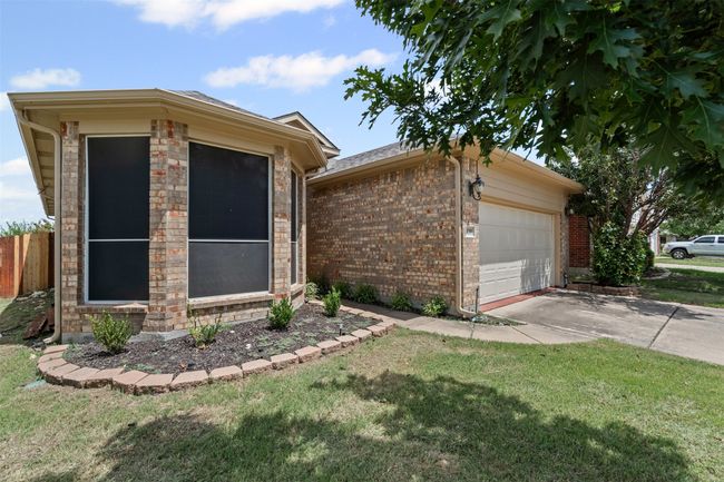View of front of house featuring driveway, an attached garage, an outdoor structure, and brick siding | Image 4