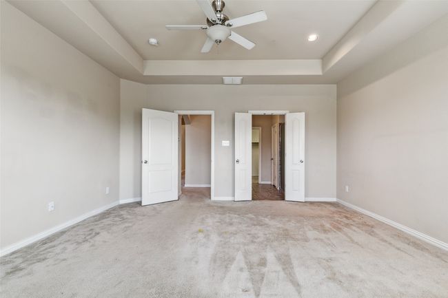 Unfurnished bedroom featuring carpet floors, baseboards, and a tray ceiling | Image 26